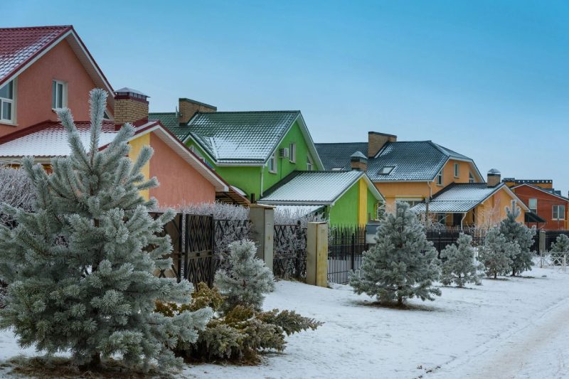 A line of colorful houses in winter snow and trees