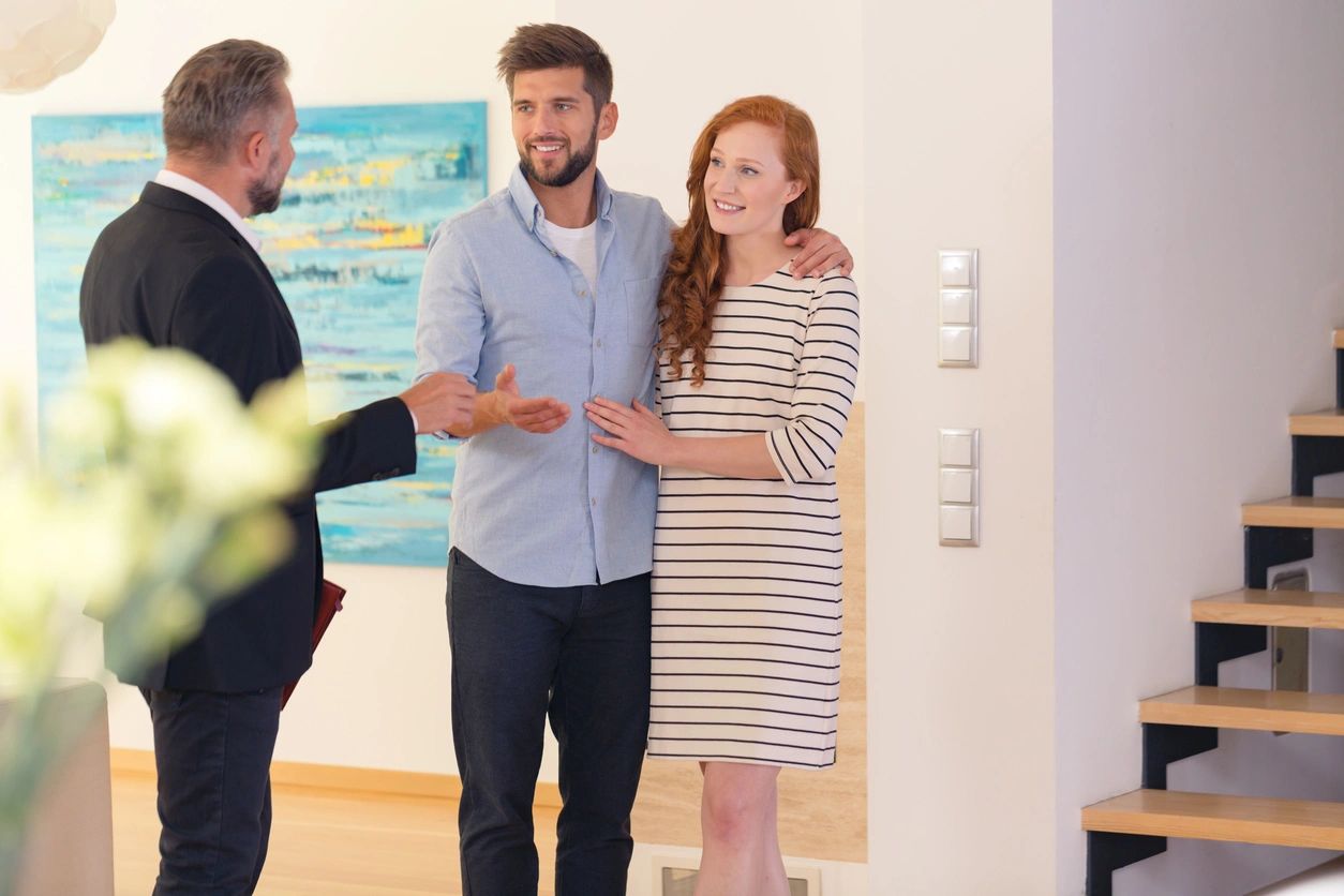 A couple talking to a man in a black suit