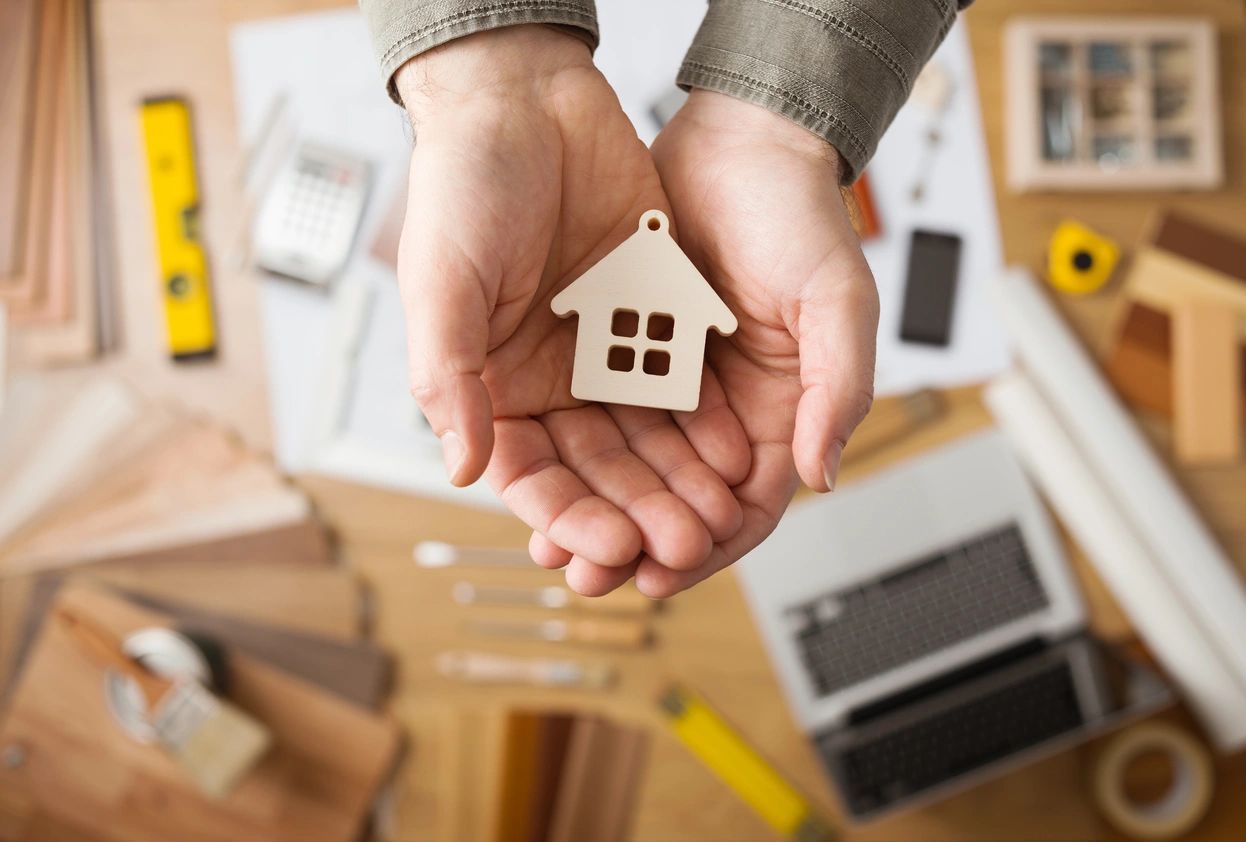 A person holding a small house key chain