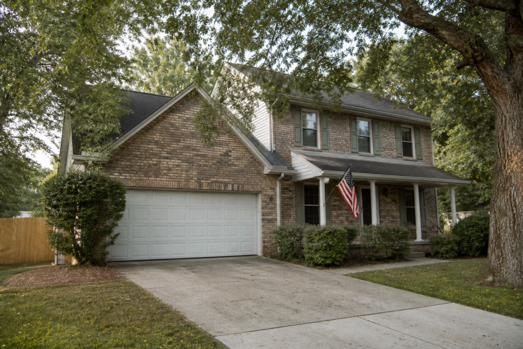 Brick suburban home with a porch flag, the kind of primary residence a veteran might buy with a VA or conventional loan