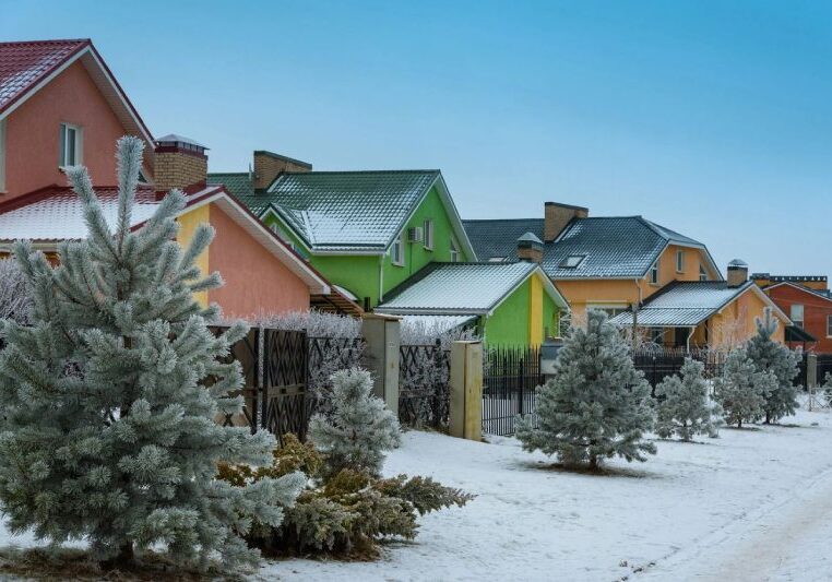 A line of colorful houses in winter snow and trees