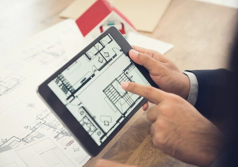 A person pointing at a blueprint on a tablet