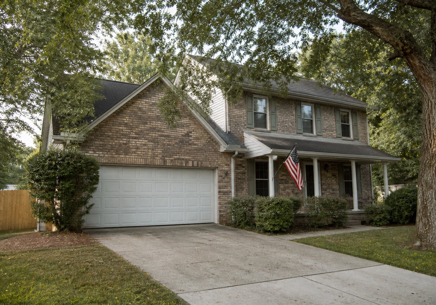 Brick suburban home with a porch flag, the kind of primary residence a veteran might buy with a VA or conventional loan